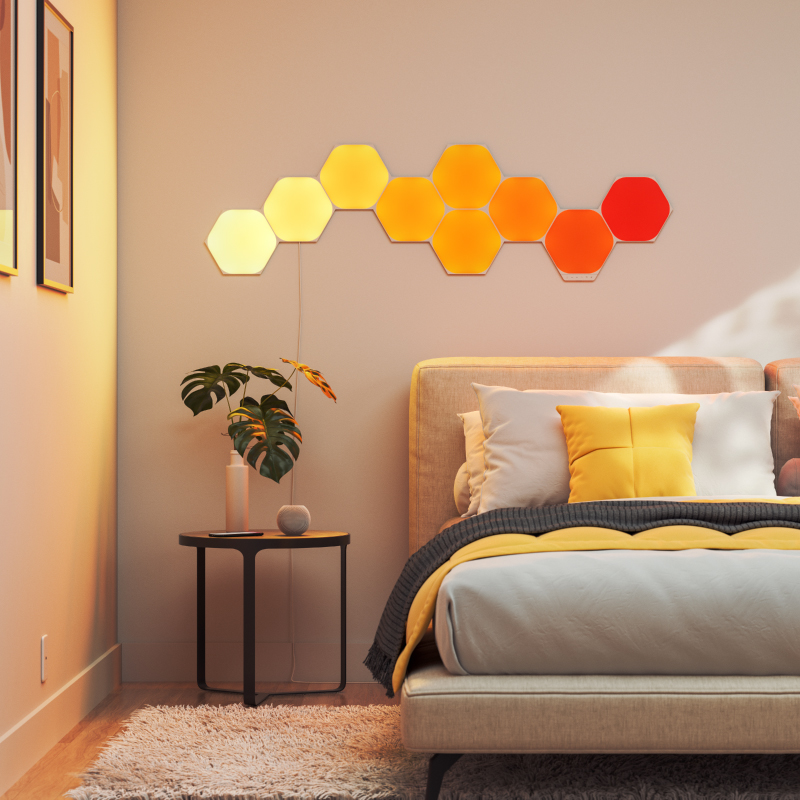 Nanoleaf Shapes Thread enabled color changing hexagon smart modular light panels mounted to a wall in a bedroom. Similar to Philips Hue, Lifx. HomeKit, Google Assistant, Amazon Alexa, IFTTT.